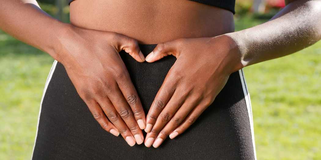 Digestive health - Woman making heart with her hands in front of her abdomen